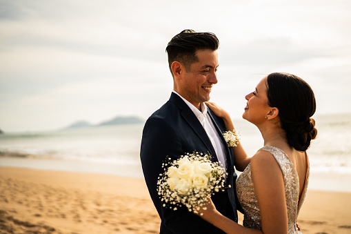 Groom and bride talking on the beach