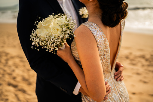 Close-up of a couple embraced on the beach