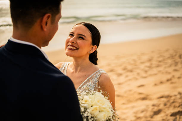 istock Bride and groom talking on the beach 1933360531