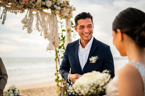 Groom talking with his bride in wedding ceremony on the beach
