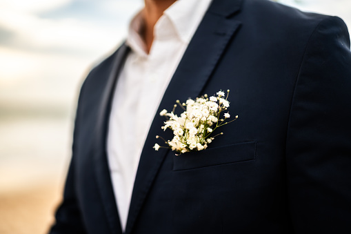 Close-up of a boutonniere on groom suit