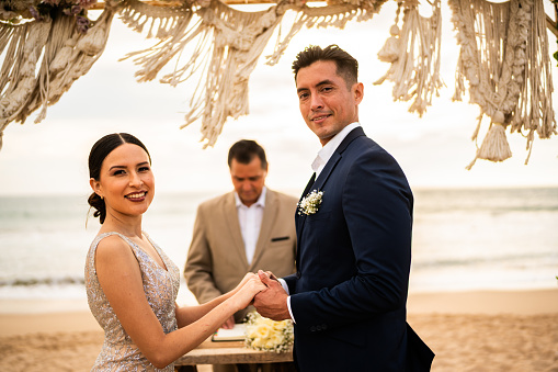 Portrait of a bride and groom in wedding ceremony on the beach