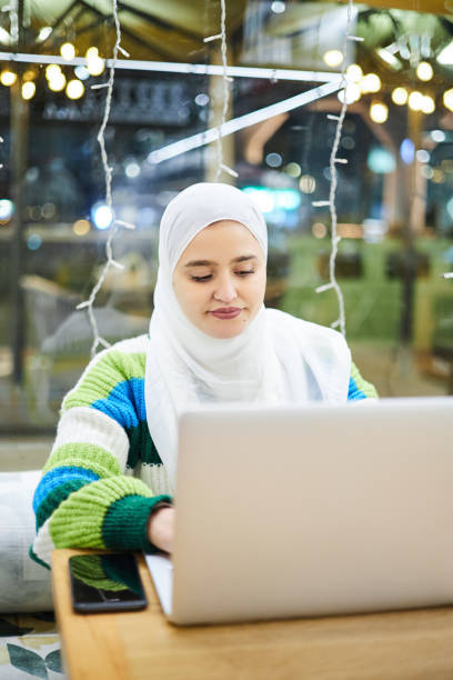 istock Young Muslim student in a bar with her laptop 1933364269