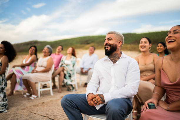 istock Wedding guests laughing during wedding ceremony on the beach 1933364812
