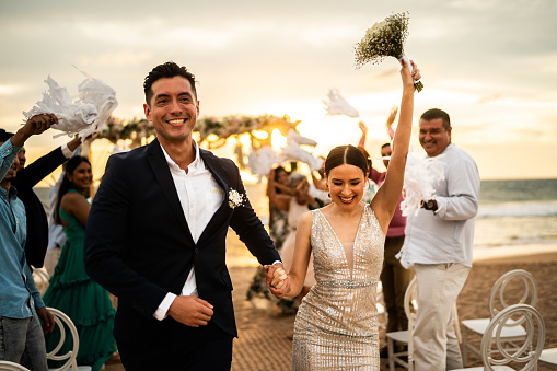 Newlyweds celebrating with their guests at beach wedding ceremony