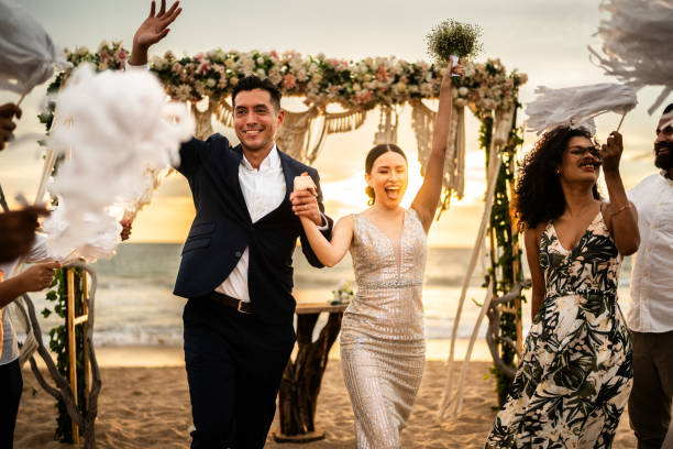 istock Newlyweds celebrating with their guests at beach wedding ceremony 1933374098