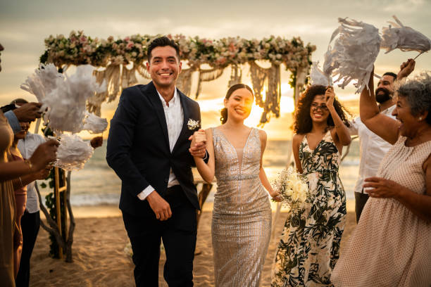 istock Newlyweds celebrating with their guests at beach wedding ceremony 1933374103