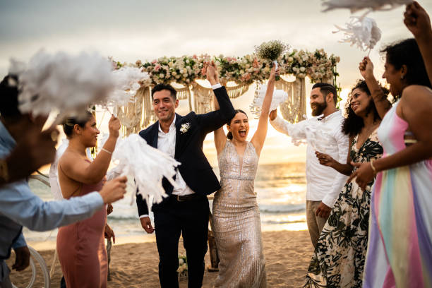 istock Newlyweds celebrating with their guests at beach wedding ceremony 1933374122