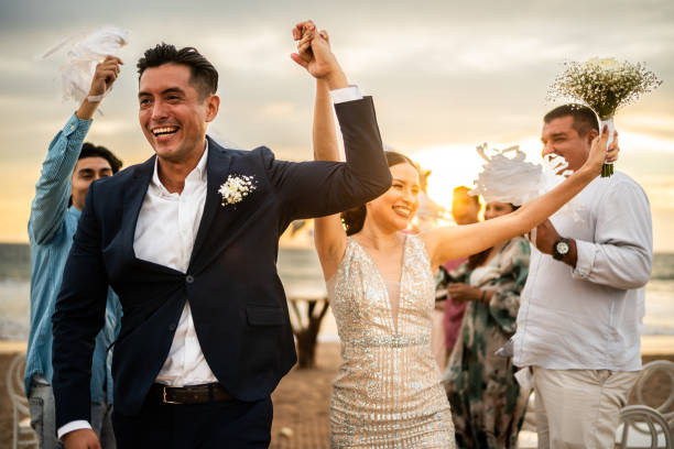 istock Newlyweds celebrating with their guests at beach wedding ceremony 1933374627