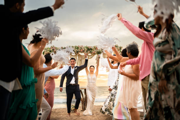 istock Newlyweds celebrating with their guests at beach wedding ceremony 1933374629