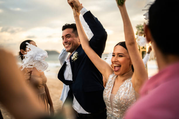 Newlyweds celebrating with their guests at beach wedding ceremony