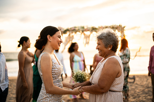 Bride talking with her grandmother after wedding ceremony on the beach