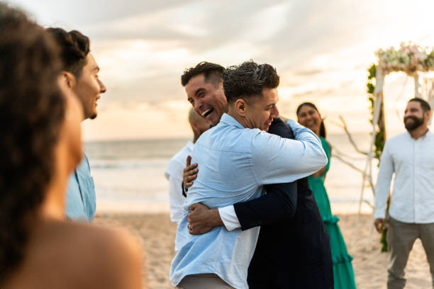istock Groom embracing his friends after wedding ceremony on the beach 1933375708