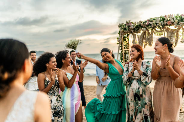Bride's friends having fun on the beach wedding party