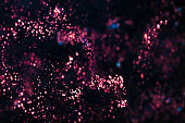A vast field of pink particles scattered across a cosmic backdrop.