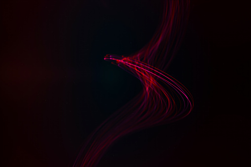 Smooth waves of red and purple light against a dark background.