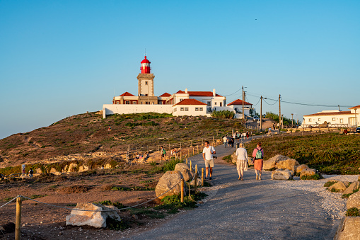 Tourists are enjoying sunset at Cabo da Roca, Westernmost Point of Continental Europe, Sintra, Portugal.
