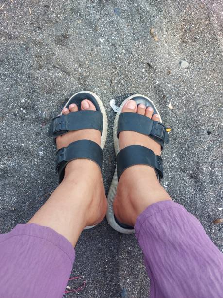 istock a woman's feet wearing sandals stepped on the sand 1933480462
