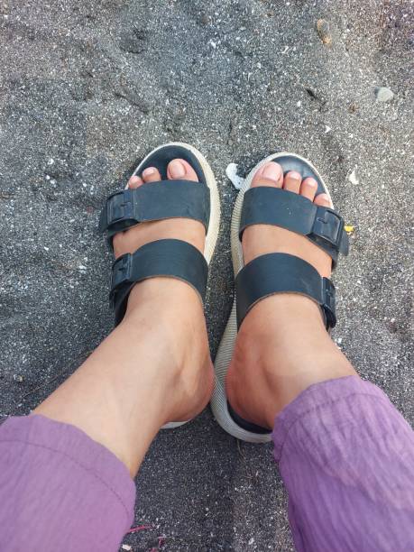 istock a woman's feet wearing sandals stepped on the sand 1933486254