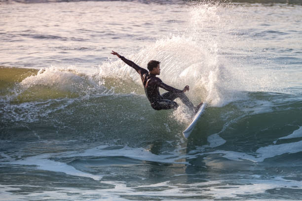 istock Sporty boy riding his surf board 1933522600