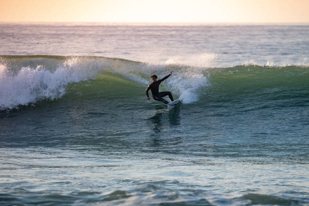 istock Sporty boy riding his surf board 1933524137