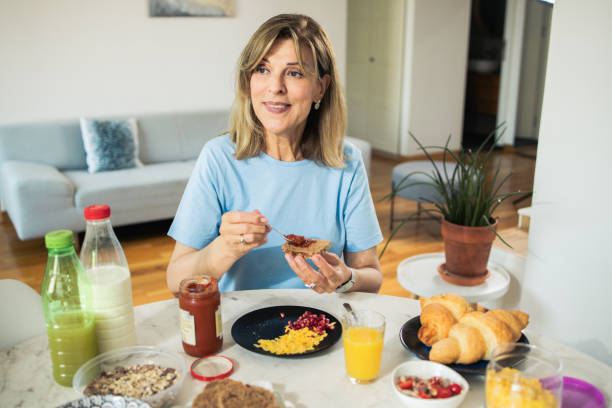 istock Happy mature woman is having breakfast 1933550103