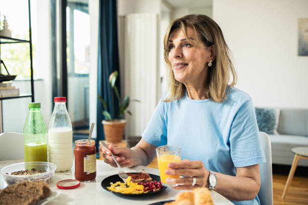 Happy mature woman is having breakfast
