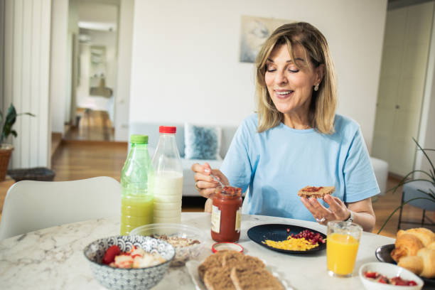 istock Middle-aged woman is having breakfast at home 1933550615