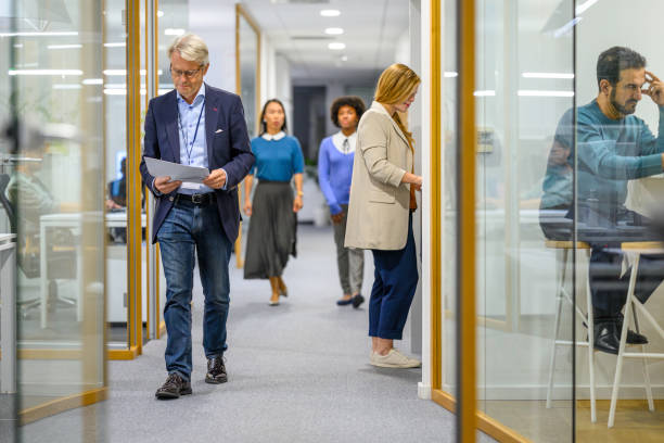 istock Coworkers chatting and walking in office corridor 1933562253