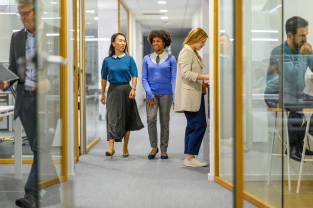 istock Coworkers chatting and walking in office corridor 1933562265