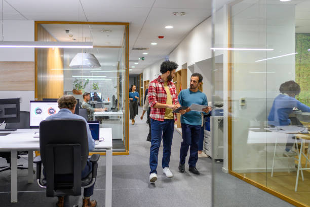 istock Coworkers chatting and walking in office corridor 1933562807