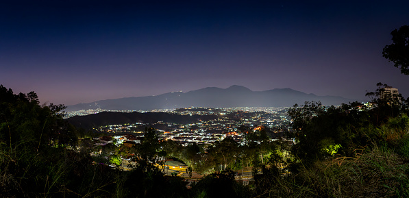 Panoramic high angle nigh time view of Caracas city valley with El Avila Mountain at the background. Huge +60 Mpix resolution of multiple composite images.