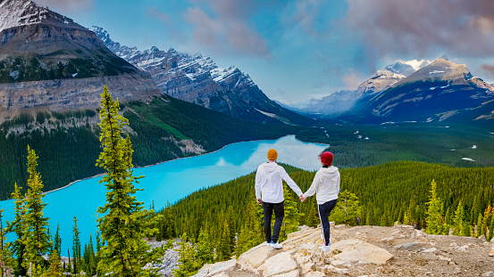 Lake Peyto Banff National Park Canada. Mountain Lake as Fox Head is popular among tourists in Canada driving Icefields parkway. a couple of men and women looking out over the turqouse colored lake