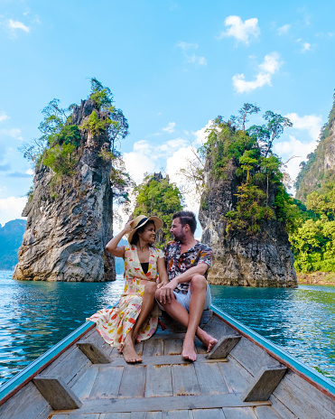 A couple of men and women in front of a longtail boat in Khao Sok Thailand, Scenic mountains on the lake in Khao Sok National Park South East Asia
