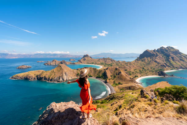 young female tourist enjoying the beautiful landscape at padar island in komodo national park, indonesia - labuanbajo stock-fotos und bilder