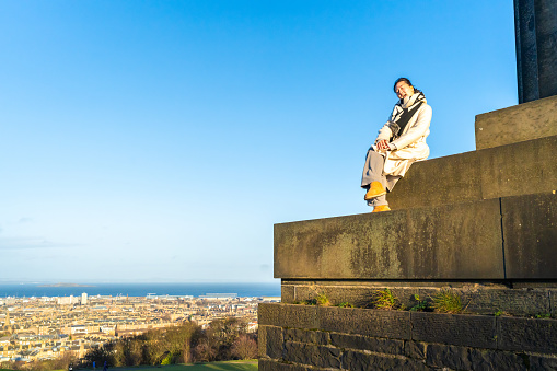 A young girl posing on the Calton Hill and national monument, Edinburgh