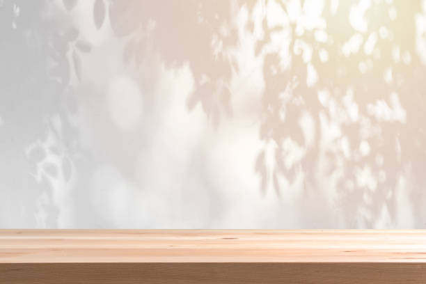 istock Abstract black and white Shadow of leaves background with empty wooden table 1933807143