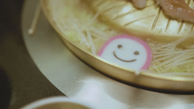 Close-up shot smile meatball Shabu Shabu (Sukiyaki) in hot pot restaurant lifestyle concept.