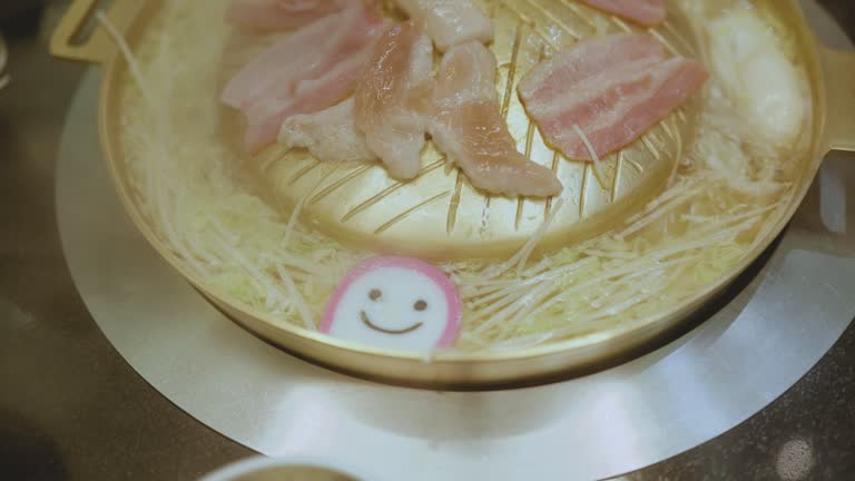 Close-up shot smile meatball Shabu Shabu (Sukiyaki) in hot pot restaurant lifestyle concept.