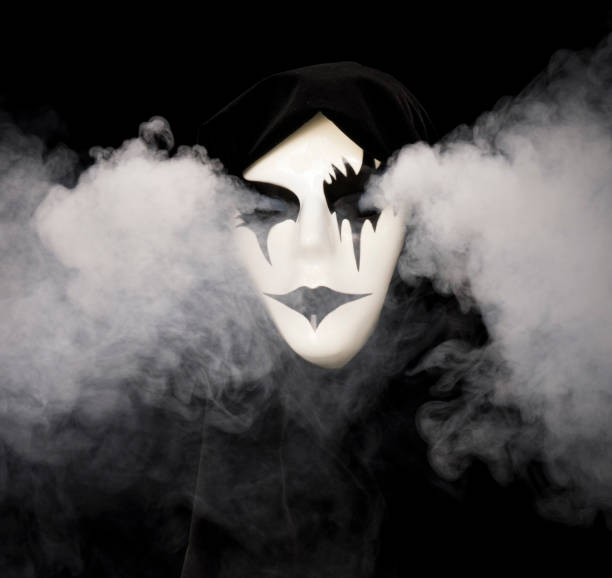 istock Cloak covered hand made mask with smoke pouring from eyes and background 1933897428