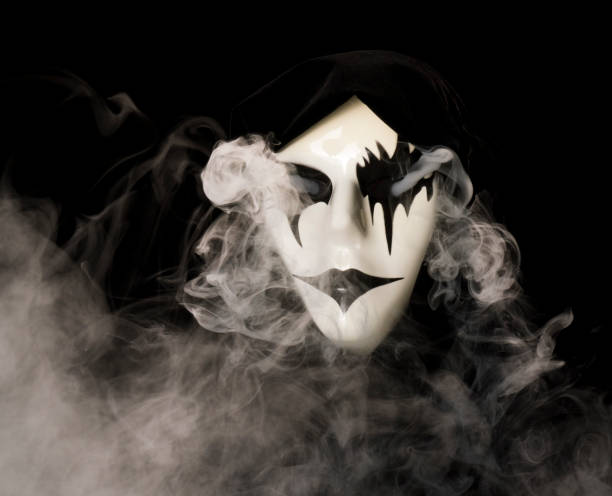 istock Cloak covered hand made mask with smoke pouring from eyes and background 1933897534