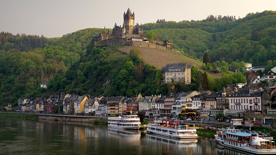 Moselle River, with hilltop Imperial Castle overlooking the town and surrounding landscape, view from the Skagerrak Bridge at sunset 'golden hour', Cochem, Germany