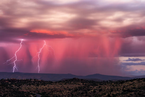Monsoon thunderstorm with lightning strikes Monsoon thunderstorm with lightning strikes and vibrant rain shafts at sunset in Arizona. monsoon stock pictures, royalty-free photos & images