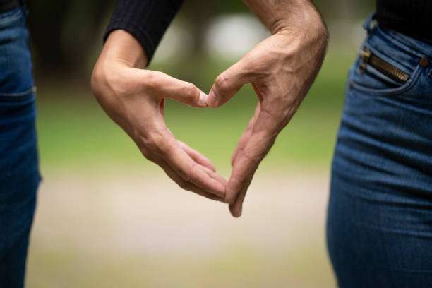 istock Couple holding hands making a heart 1933947456