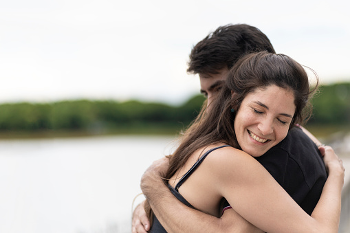 Couple hugging and smiling on a lake