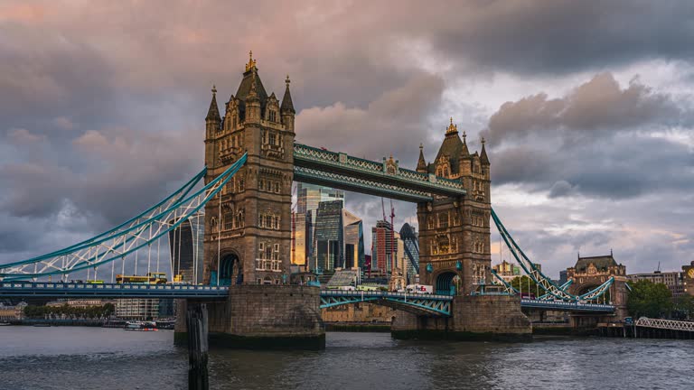 4K Footage Time lapse of Crowded Commuter people walking and traffic on the Tower Bridge and Financial glass office building riverbank in downtown district of London