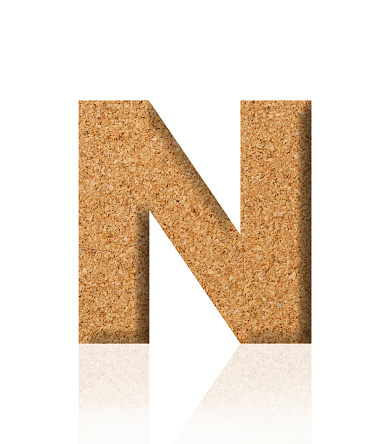 Close-up of three-dimensional cork alphabet letter N on white background.