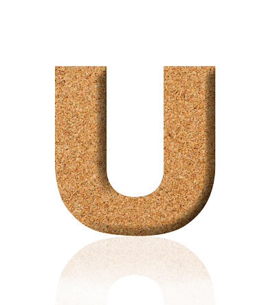Close-up of three-dimensional cork alphabet letter U on white background.