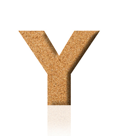 Close-up of three-dimensional cork alphabet letter Y on white background.