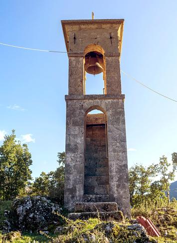 Old bell tower in the village near the church on a sunny, winter day (Peloponnese, Greece) in the mountains close-up.